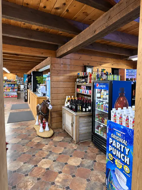 Wine and liquor shelves by the counter, past the horse statue